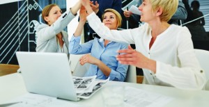 Team vor Computer macht High Five